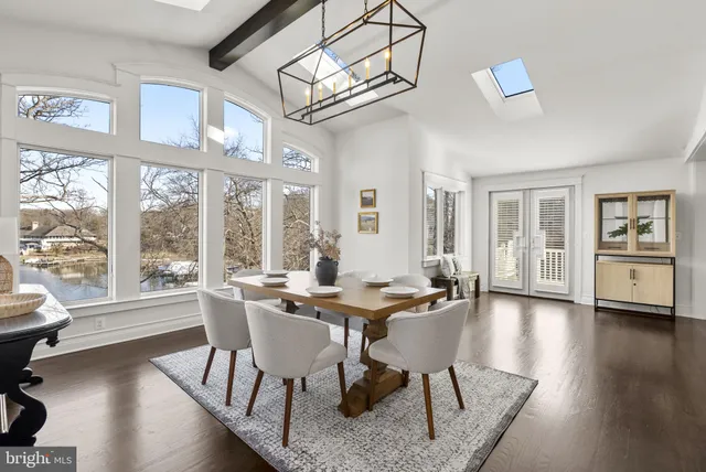 a dining room with furniture a chandelier and wooden floor