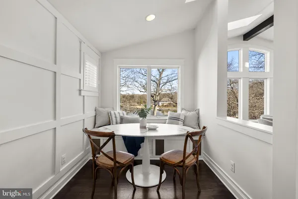 a kitchen with a dining table chairs stainless steel appliances and cabinets