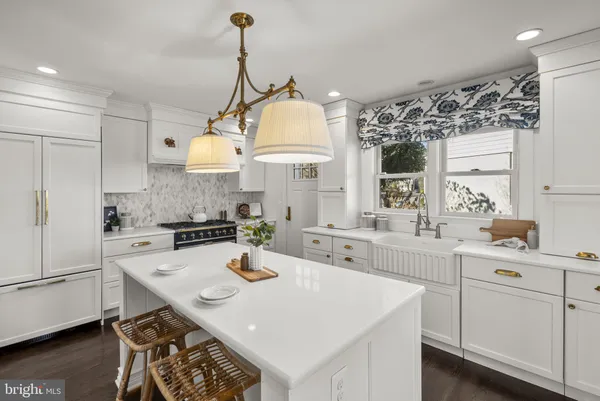 a kitchen with a sink stove and wooden floor