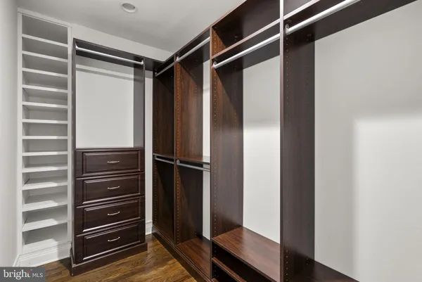 an empty room with wooden floor cabinet and windows