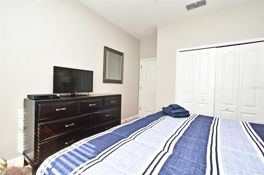 8878 Candy Palm Road Kissimmee, FL 34747 - Photo 28 of 70 a bedroom with a bed and a flat screen tv
