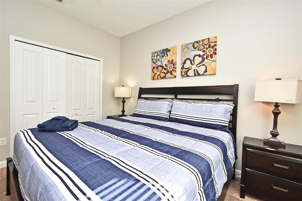 8878 Candy Palm Road Kissimmee, FL 34747 - Photo 29 of 70 a bedroom with a bed and a lamp on dresser