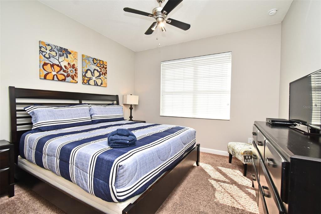 8878 Candy Palm Road Kissimmee, FL 34747 - Photo 30 of 70 a bedroom with a bed and a flat screen tv