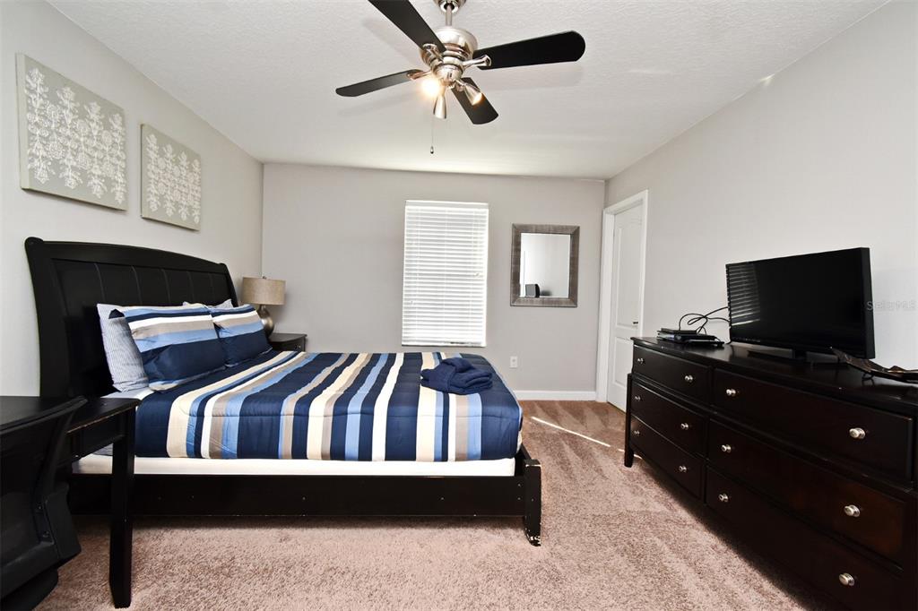 8878 Candy Palm Road Kissimmee, FL 34747 - Photo 36 of 70 a bedroom with a bed and a flat screen tv