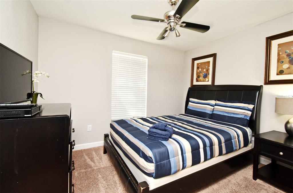 8878 Candy Palm Road Kissimmee, FL 34747 - Photo 38 of 70 a bedroom with a bed and a flat screen tv