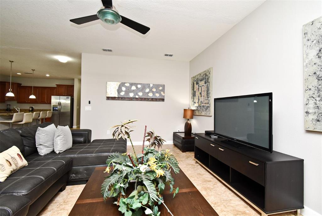 8878 Candy Palm Road Kissimmee, FL 34747 - Photo 4 of 70 a living room with furniture and a flat screen tv