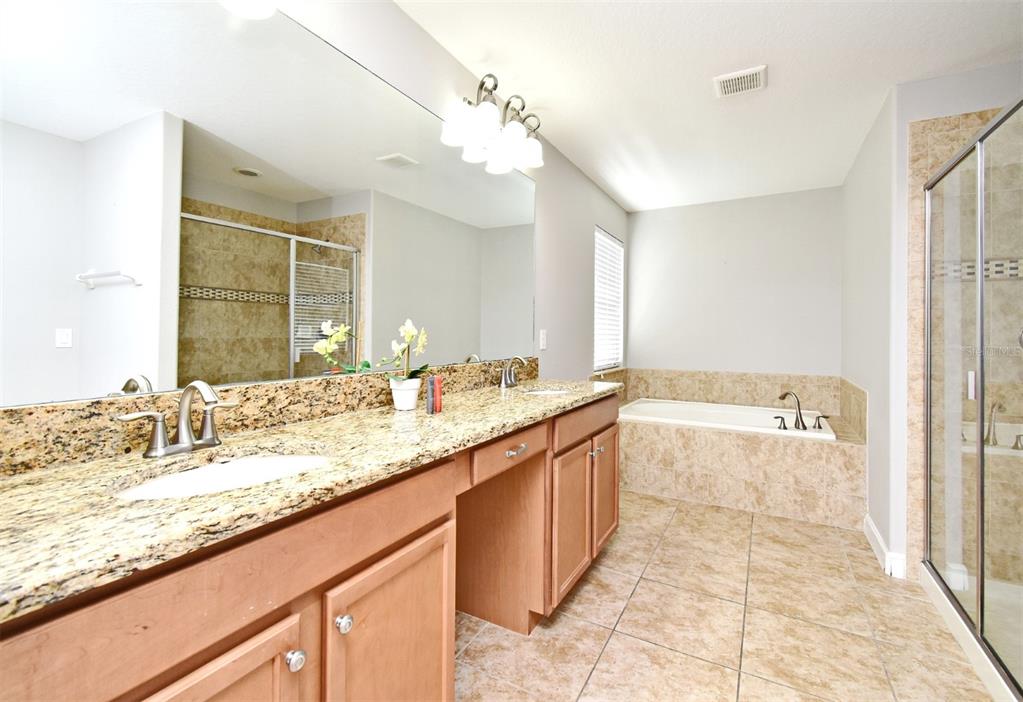 8878 Candy Palm Road Kissimmee, FL 34747 - Photo 51 of 70 a bathroom with a granite countertop sink and a mirror