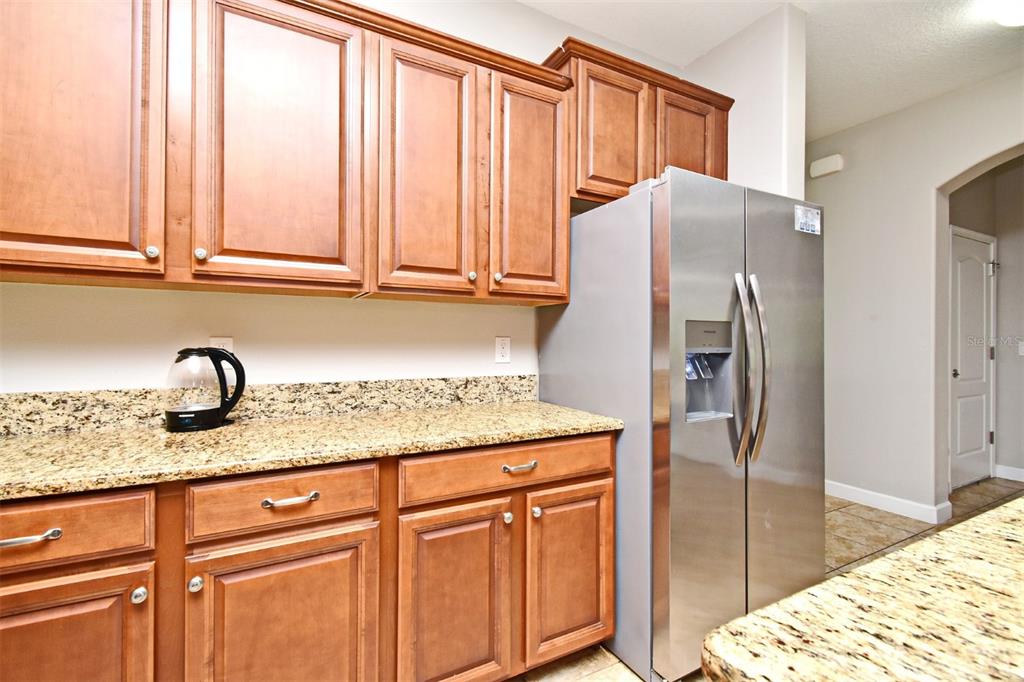 8878 Candy Palm Road Kissimmee, FL 34747 - Photo 10 of 70 a kitchen with stainless steel appliances granite countertop a refrigerator and a sink