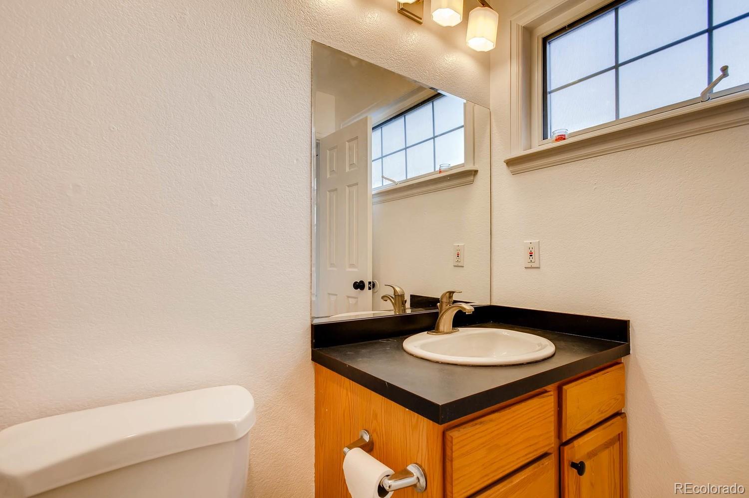 303 West Baseline Road Lafayette, CO 80026 - Photo 13 of 28 a bathroom with a sink toilet and a mirror