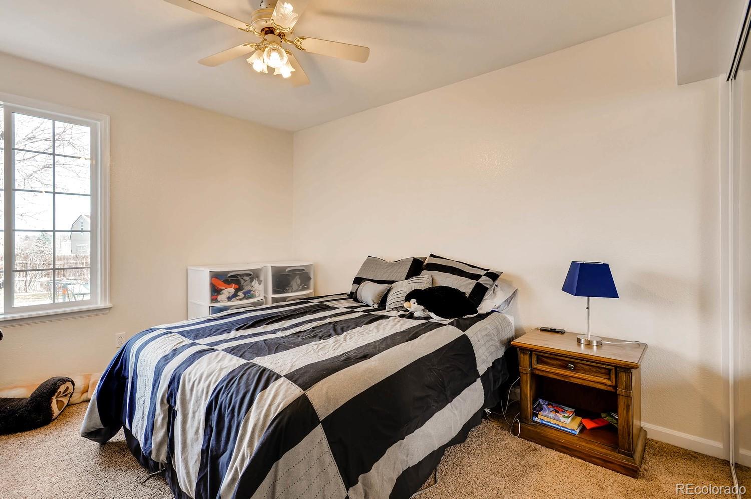 303 West Baseline Road Lafayette, CO 80026 - Photo 15 of 28 a bedroom with a bed and a chandelier