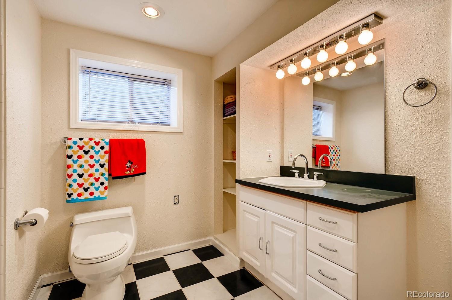 303 West Baseline Road Lafayette, CO 80026 - Photo 23 of 28 a bathroom with a sink vanity mirror and toilet