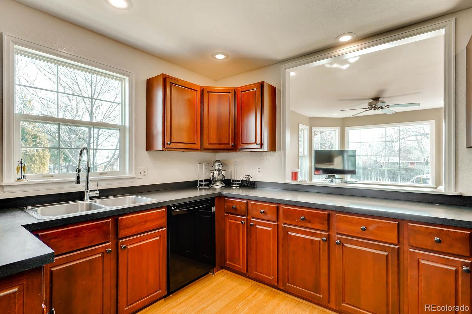 303 West Baseline Road Lafayette, CO 80026 - Photo 9 of 28 a kitchen with stainless steel appliances granite countertop wooden cabinets a sink and a large window