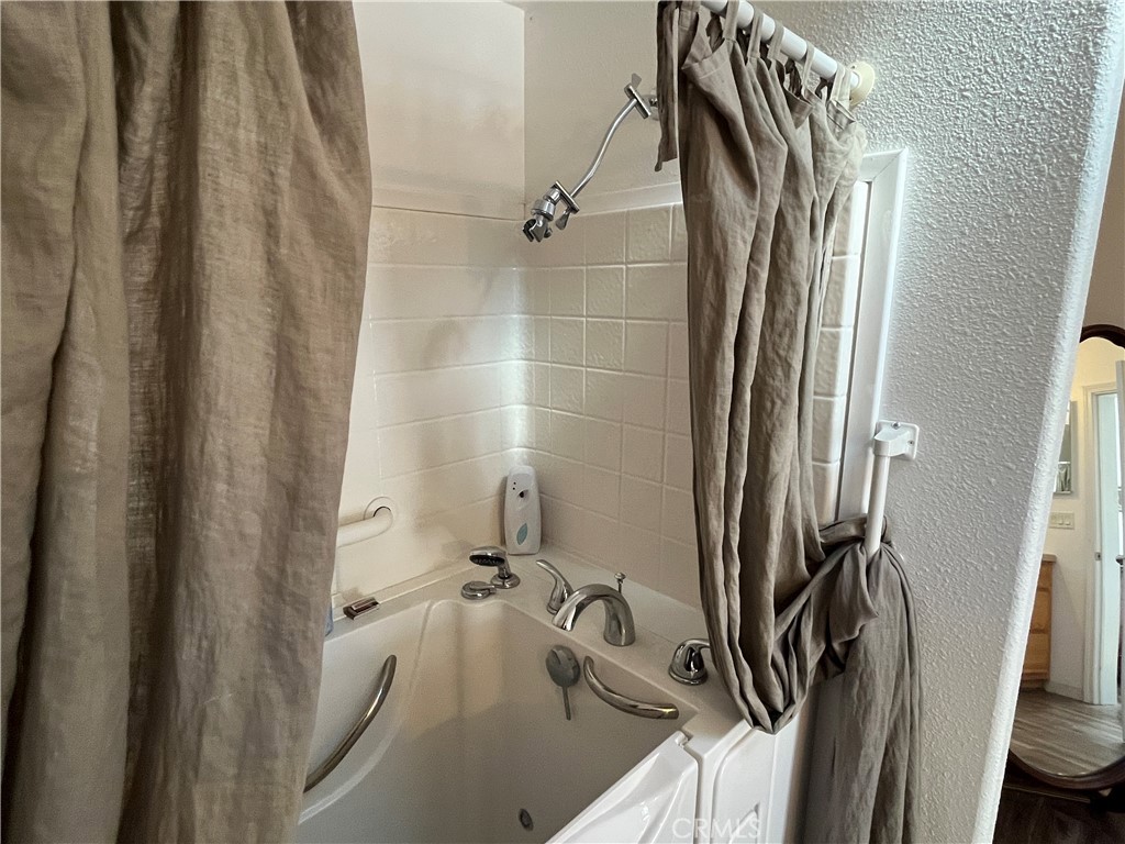 39950 7 Oaks Road, Unit 41 Angelus Oaks, CA 92305 - Photo 25 of 27 a bathroom with a tub a sink and a wooden floor