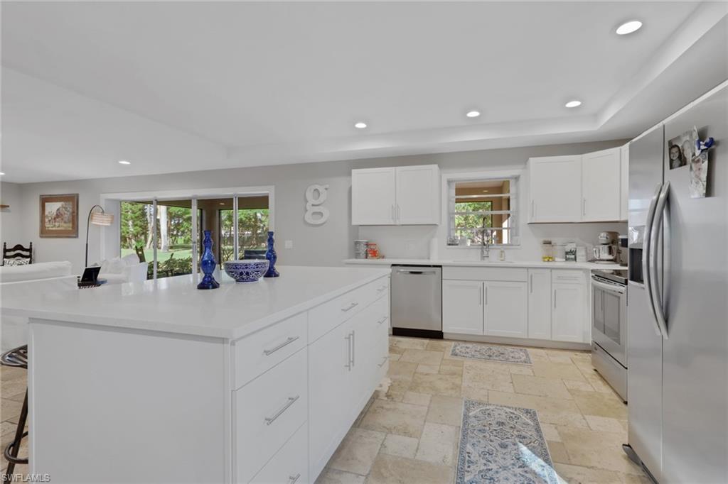 687 Cypress Way East Naples, FL 34110 - Photo 11 of 27 a kitchen with white cabinets and white appliances