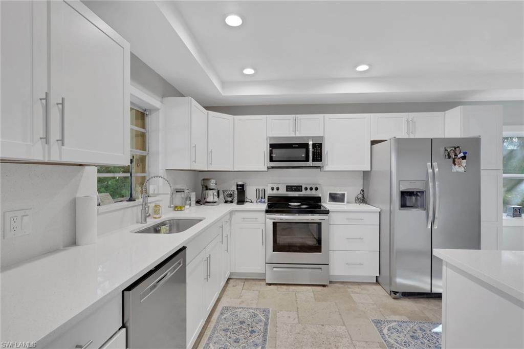 687 Cypress Way East Naples, FL 34110 - Photo 12 of 27 a kitchen with white cabinets stainless steel appliances and a sink