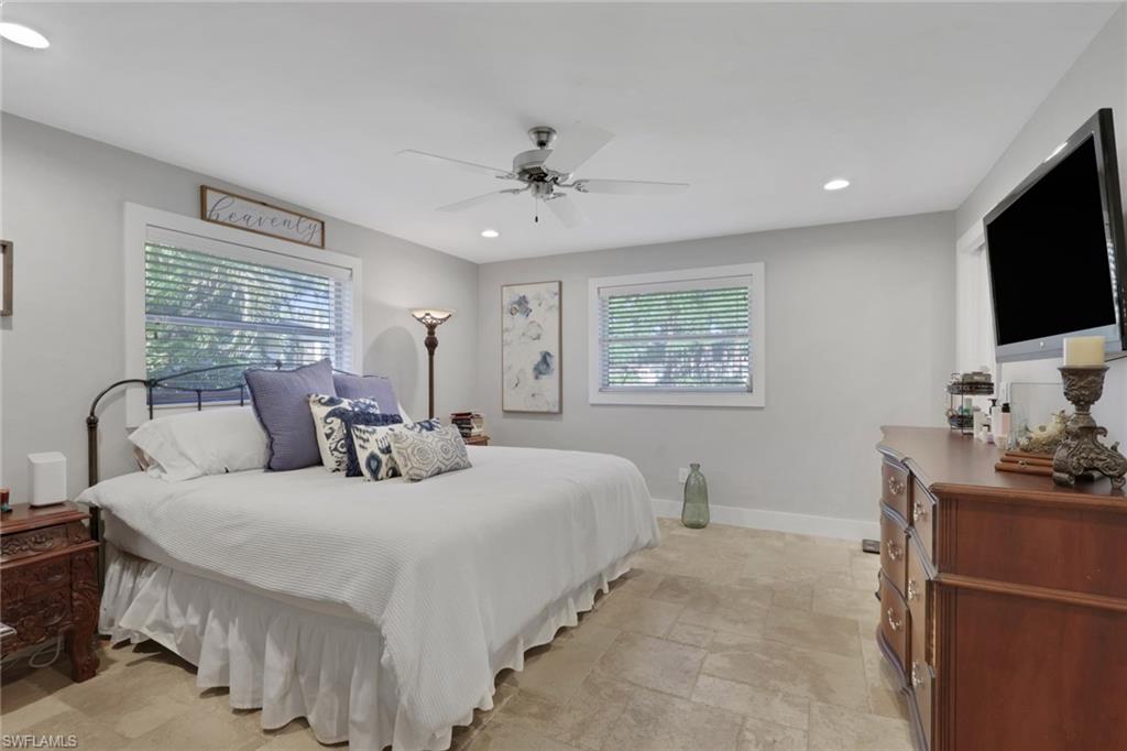 687 Cypress Way East Naples, FL 34110 - Photo 15 of 27 a bedroom with a bed and a flat screen tv