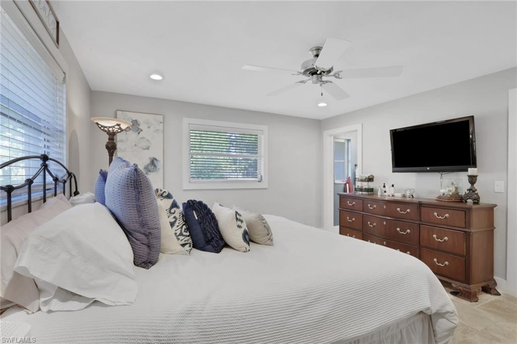 687 Cypress Way East Naples, FL 34110 - Photo 16 of 27 a bedroom with a bed and a flat screen tv