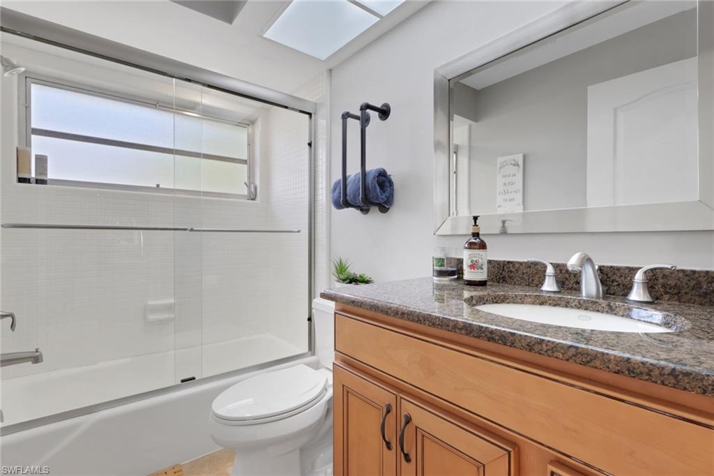 687 Cypress Way East Naples, FL 34110 - Photo 20 of 27 a bathroom with a granite countertop sink toilet and shower