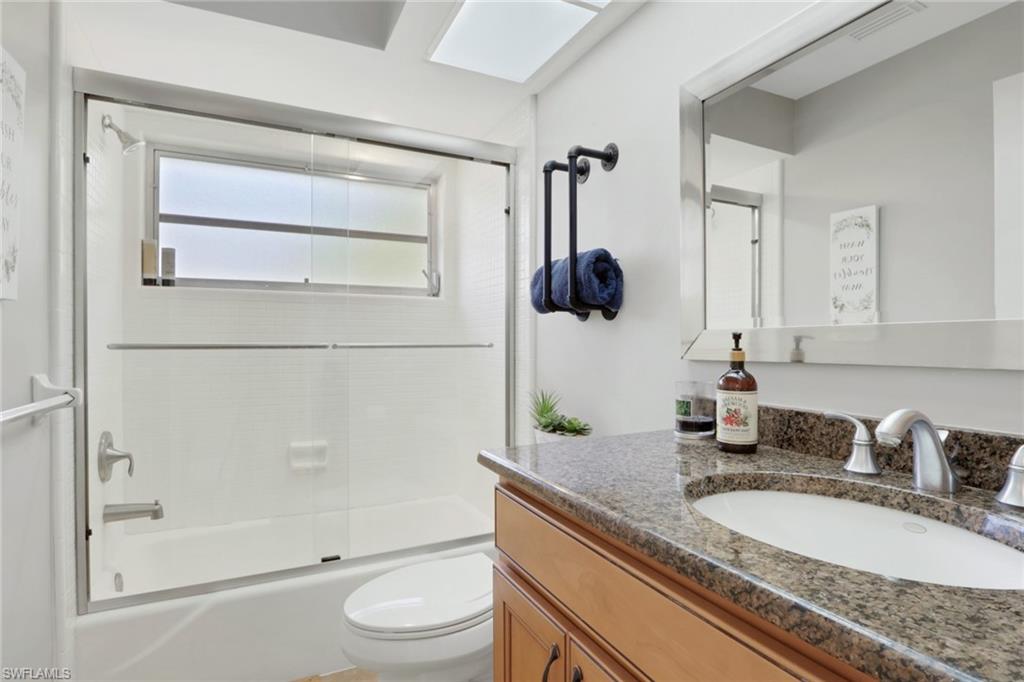 687 Cypress Way East Naples, FL 34110 - Photo 21 of 27 a bathroom with a granite countertop sink a toilet and shower