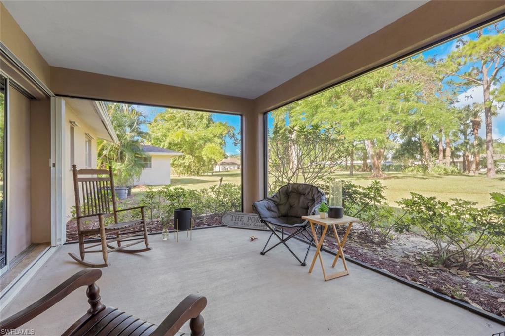 687 Cypress Way East Naples, FL 34110 - Photo 26 of 27 a living room with furniture and a floor to ceiling window