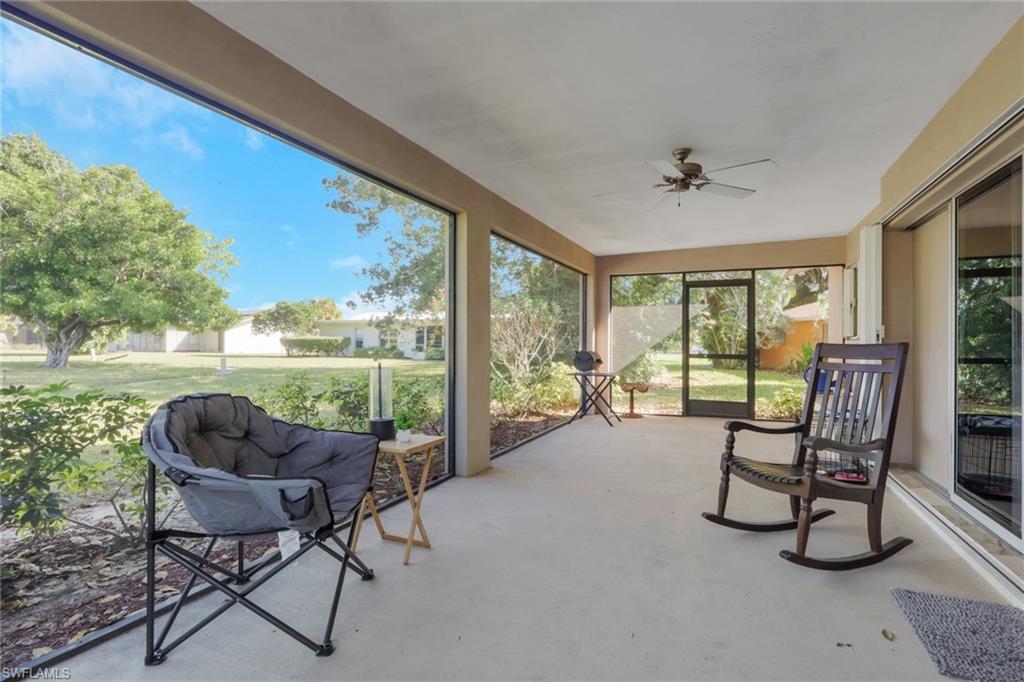 687 Cypress Way East Naples, FL 34110 - Photo 27 of 27 a living room with furniture and a floor to ceiling window