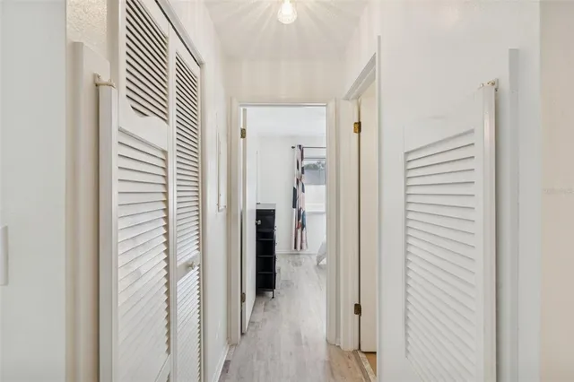 a view of a hallway with closet and wooden floor