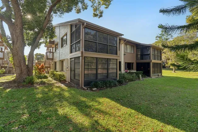 an aerial view of residential houses with outdoor space and trees