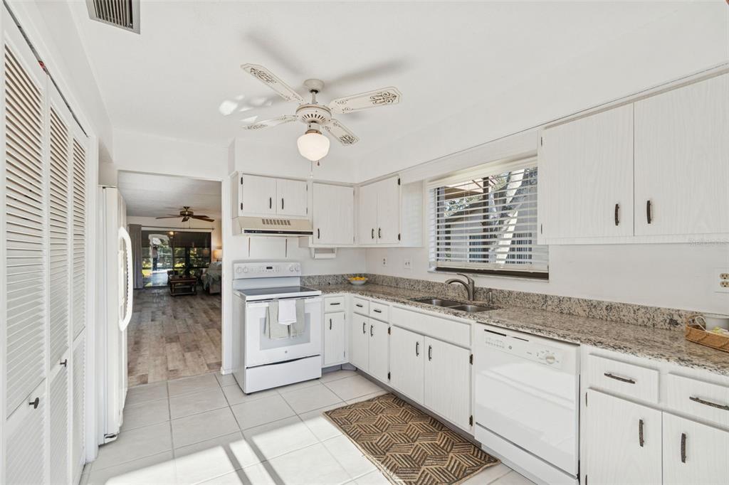 12906 Wedgewood Way, Unit D Hudson, FL 34667 - Photo 6 of 54 a kitchen with a sink dishwasher and white cabinets with wooden floor