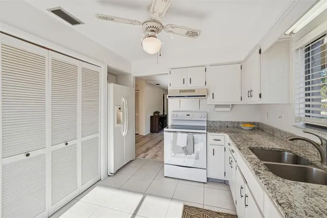 a kitchen with granite countertop a sink a counter top space stainless steel appliances and cabinets