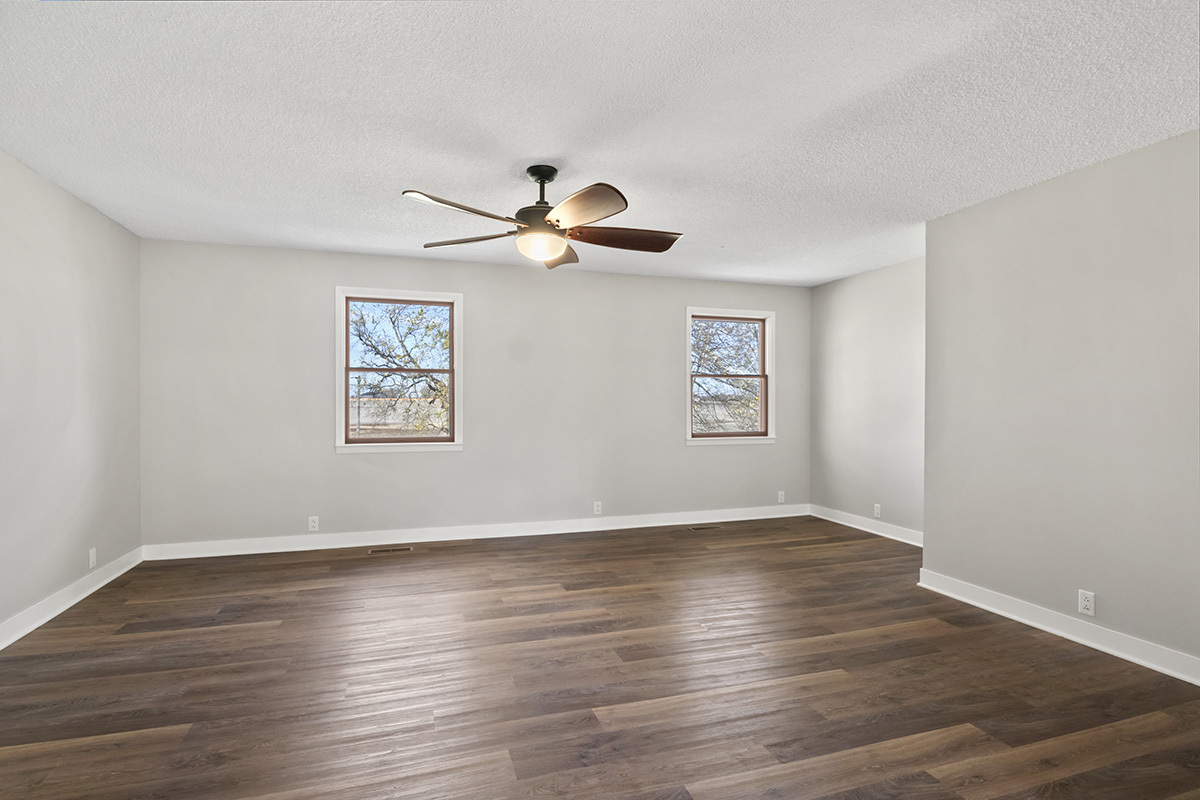 12945 Smith Road Manhattan, IL 60442 - Photo 10 of 43 an empty room with wooden floor chandelier fan and windows