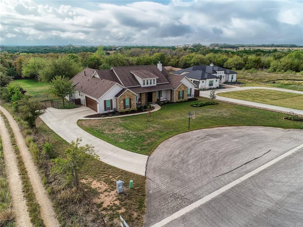 132 Huerta Road Florence, TX 76527 - Photo 35 of 40 An aerial perspective reveals a winding concrete driveway leading to a charming house nestled amidst green landscaping.