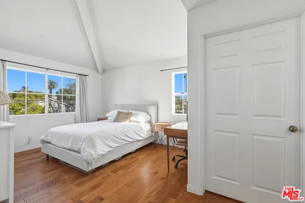 a bedroom with a bed and a large window