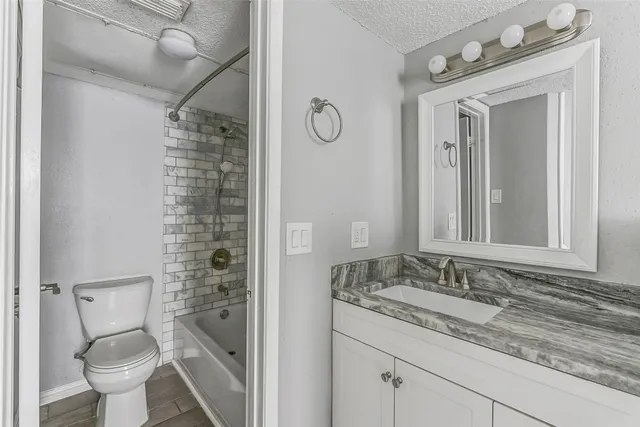 a bathroom with a granite countertop sink toilet and shower