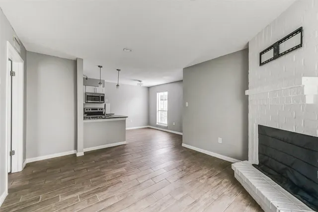 a view of kitchen with wooden floor and electronic appliances