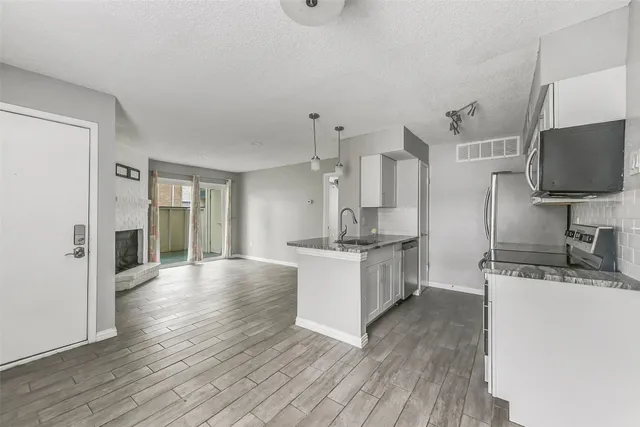 a large kitchen with cabinets wooden floor and stainless steel appliances