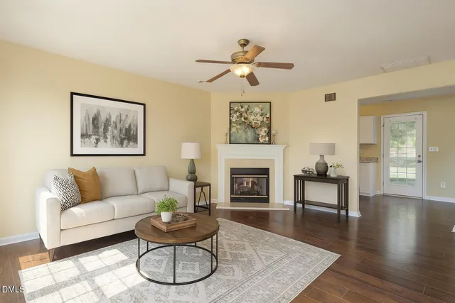 a living room with furniture a fireplace and wooden floor