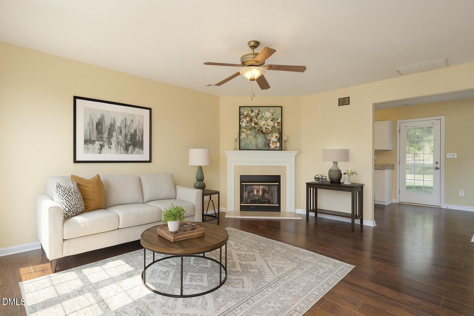 a living room with furniture a fireplace and wooden floor