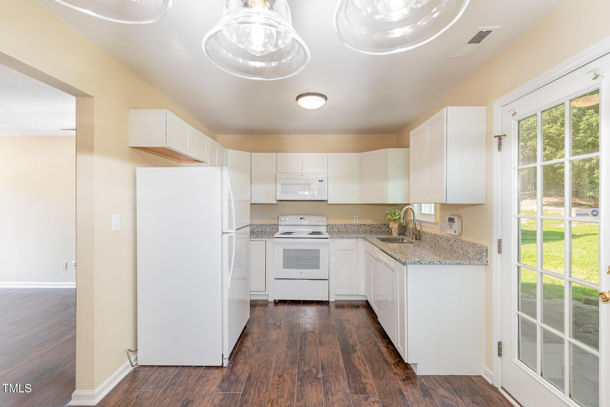 2125 Ventana Lane Raleigh, NC 27604 - Photo 5 of 19 a kitchen with kitchen island granite countertop a sink cabinets and wooden floor
