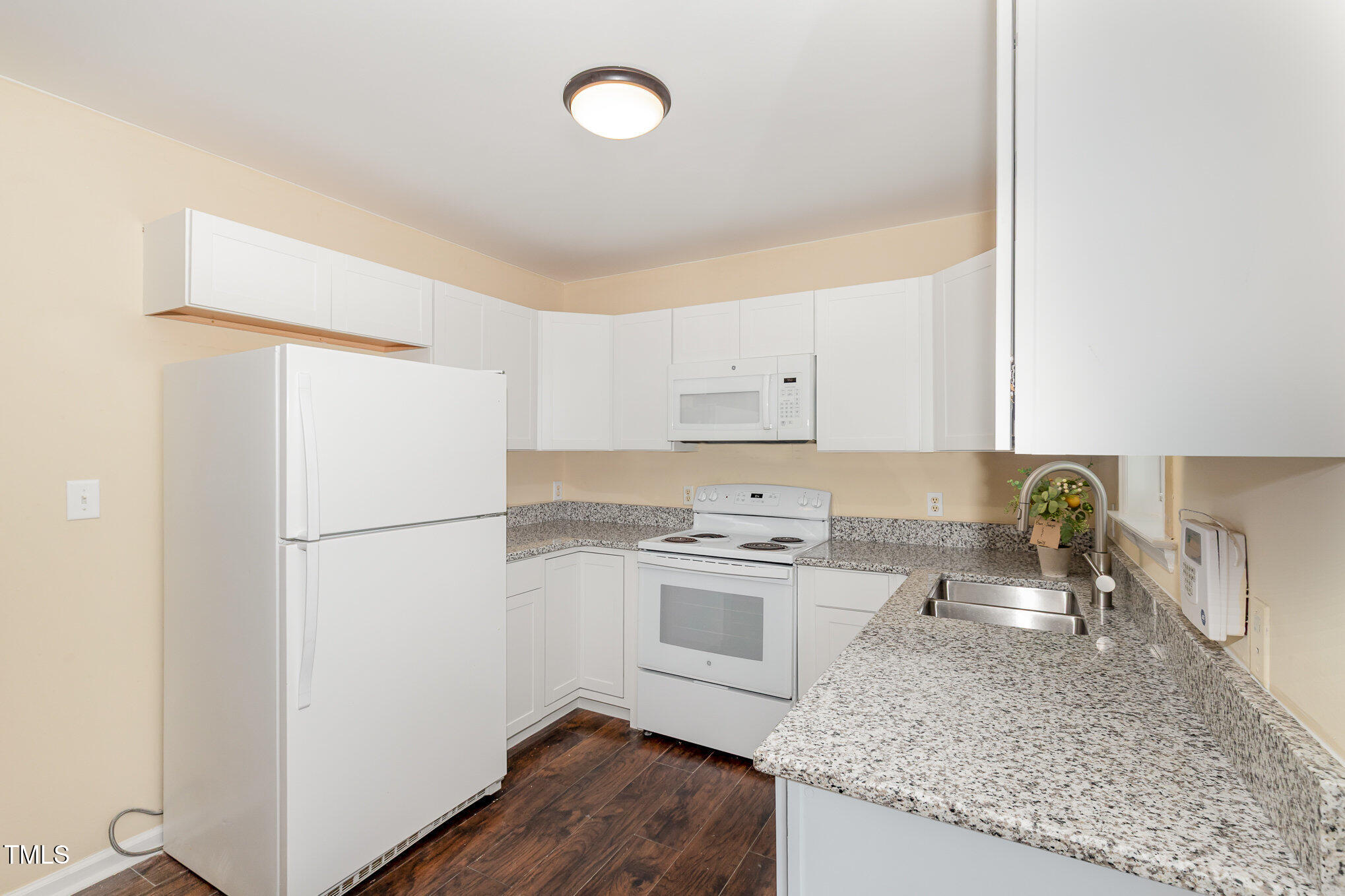 2125 Ventana Lane Raleigh, NC 27604 - Photo 6 of 19 a kitchen with a sink a stove a refrigerator and white cabinets