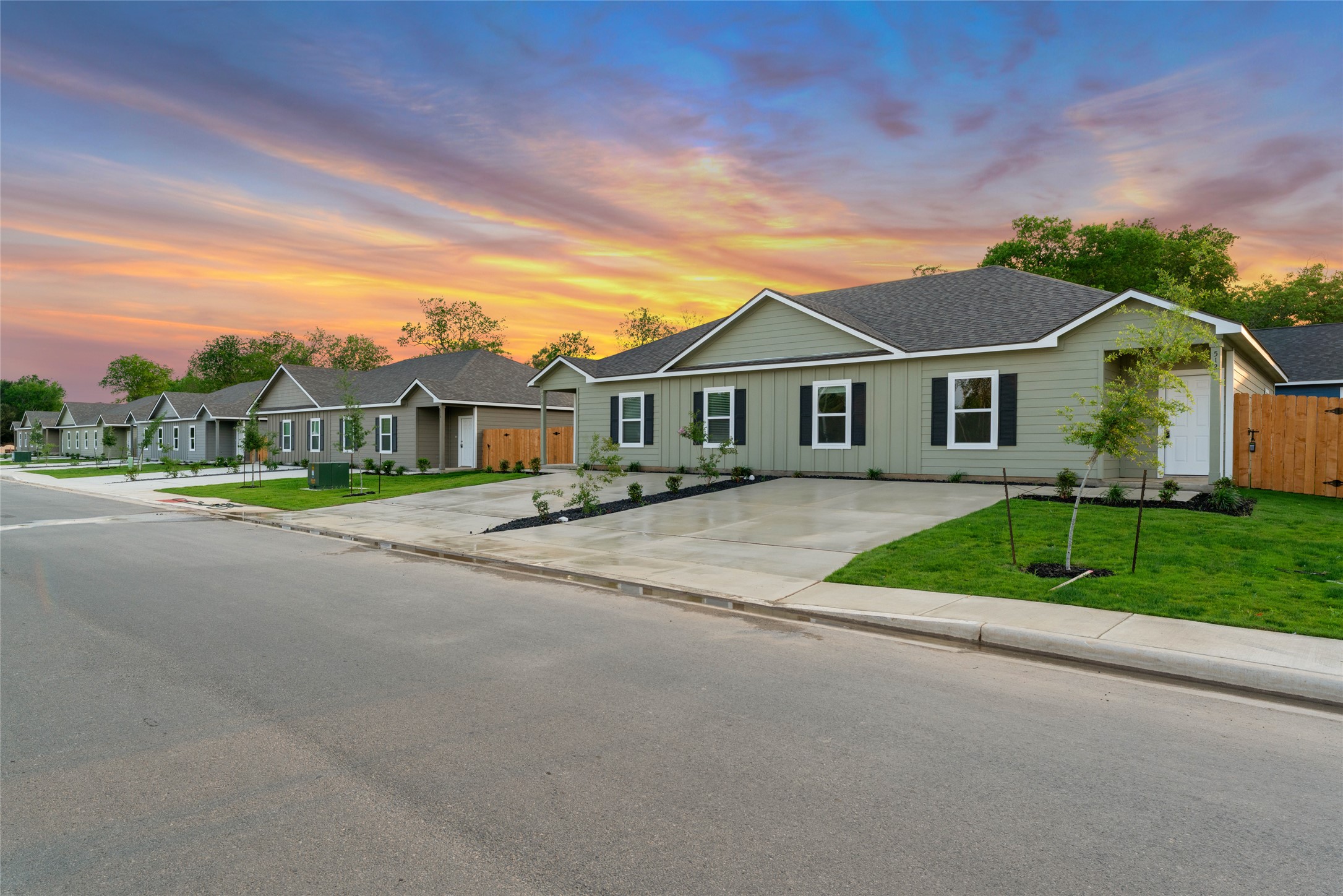 Ranch-style house featuring roof with shingles, board and batten siding, and driveway