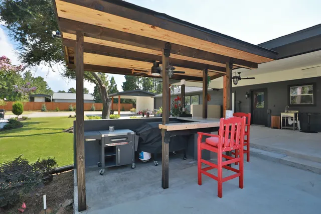 a view of a house with backyard and sitting area
