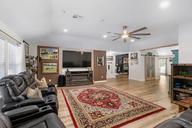 a kitchen with stainless steel appliances granite countertop a table chairs sink refrigerator and cabinets
