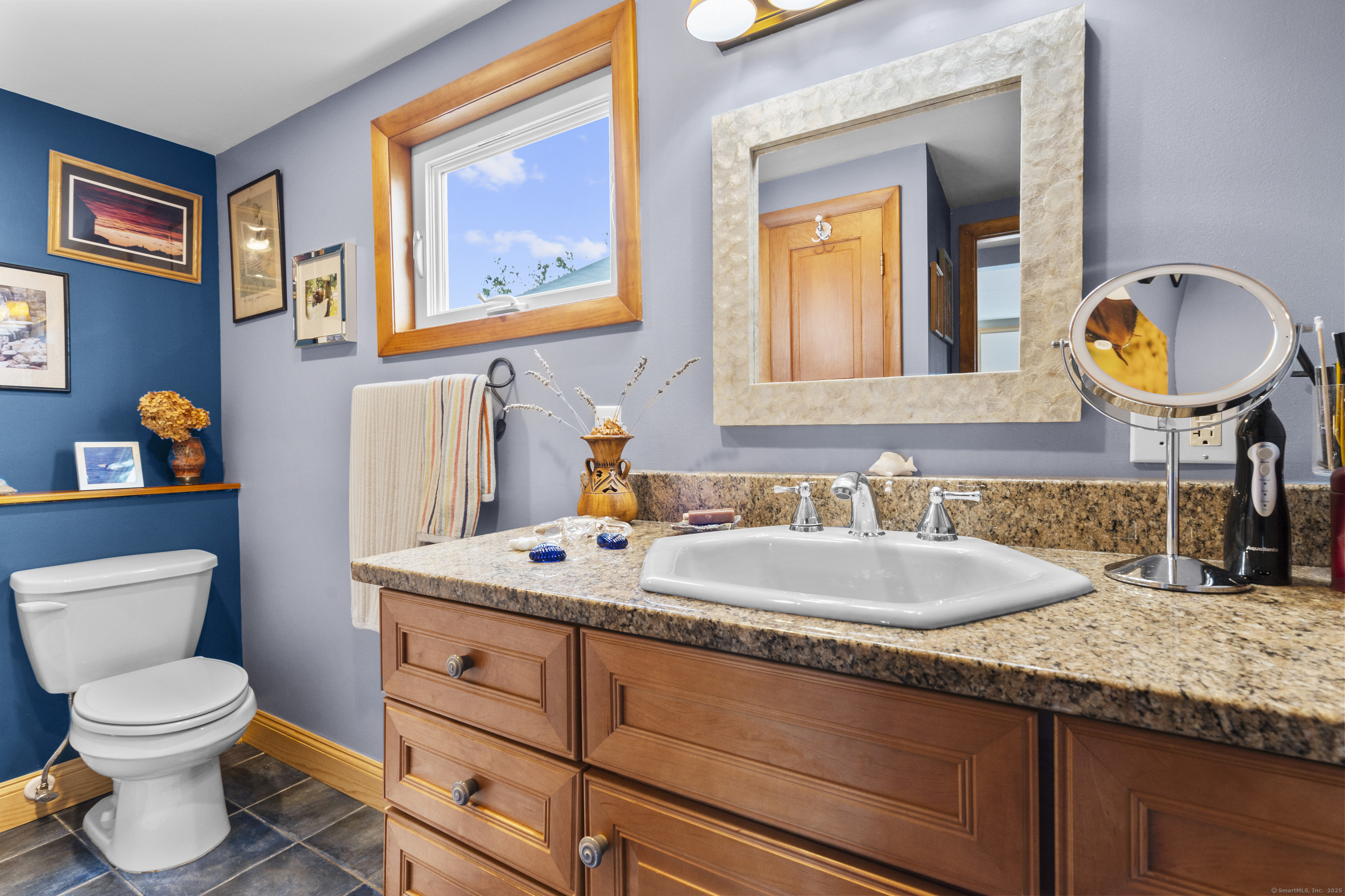 38 Elaine Road Milford, CT 06460 - Photo 3 of 13 a bathroom with a granite countertop toilet a sink and a mirror