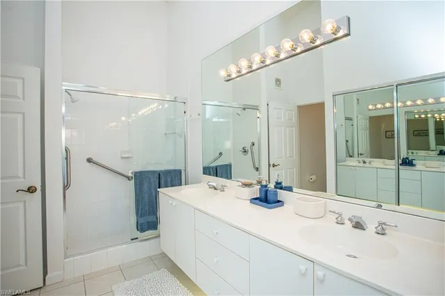a bathroom with a double vanity sink mirror and shower