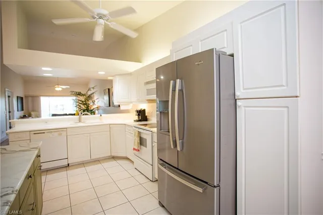 a kitchen with white cabinets and white stainless steel appliances