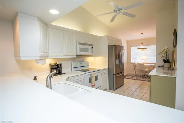 a kitchen with stainless steel appliances a stove refrigerator sink and microwave