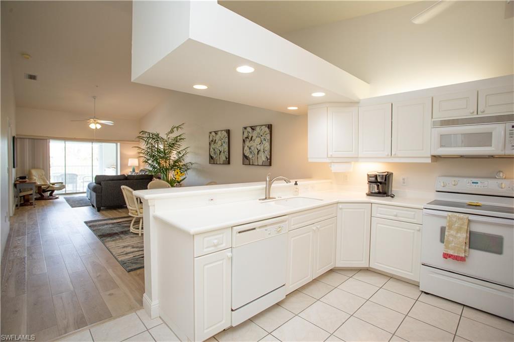 6760 Beach Resort Drive, Unit 2 Naples, FL 34114 - Photo 4 of 24 a kitchen with a sink window and cabinets