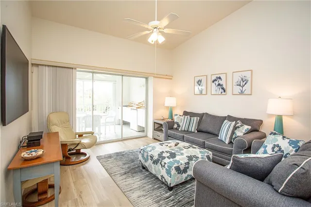 a living room with furniture and a large window with garden view