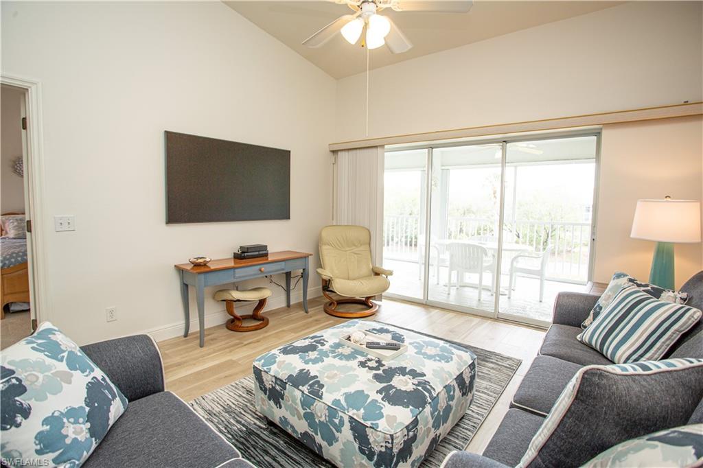 6760 Beach Resort Drive, Unit 2 Naples, FL 34114 - Photo 9 of 24 a living room with furniture a flat screen tv and a large window