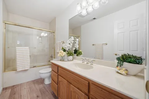 a bathroom with a granite countertop sink a toilet and shower